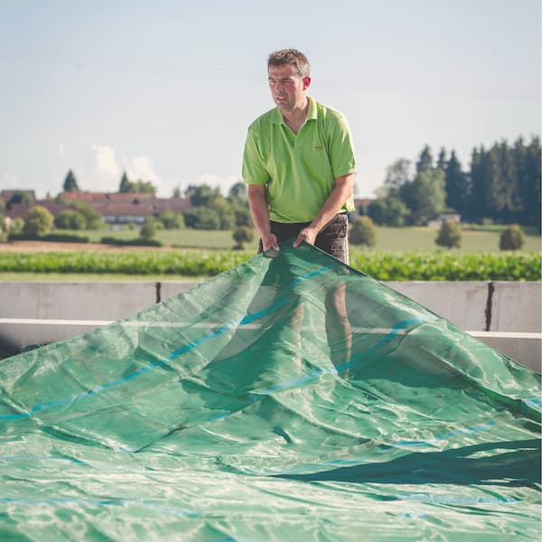 Landwirt beim Silo abdecken